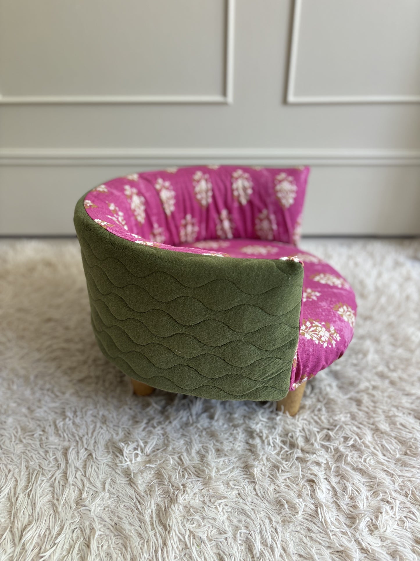 Side view, bright pink floral cover with army green quilted backing